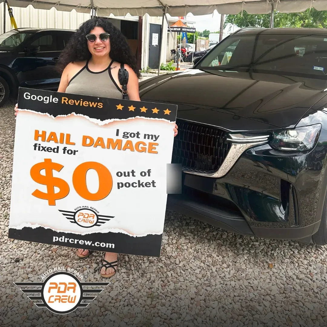 PDR Crew customer holding a sign that reads I got my hail damage fixed for $0 out of pocket