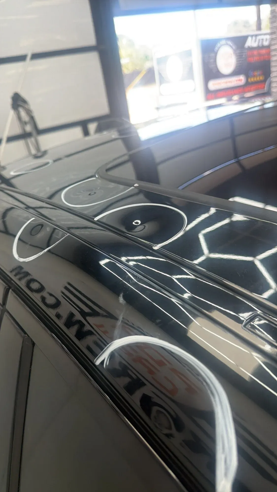 Car roof under the shop’s hexagon lights with hail dents circled