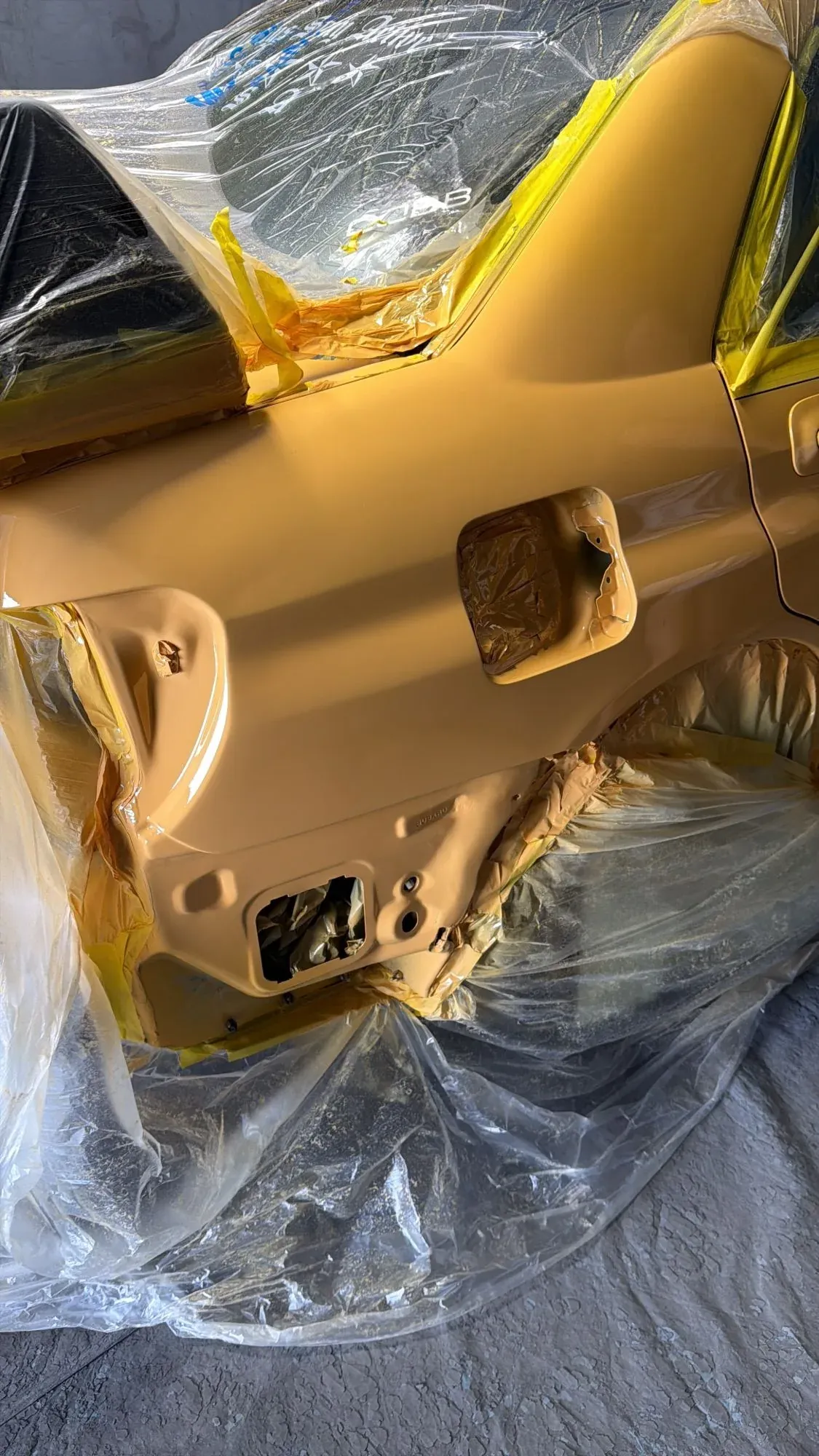 Quarter panel freshly sprayed with every opening and the rest of the car masked off