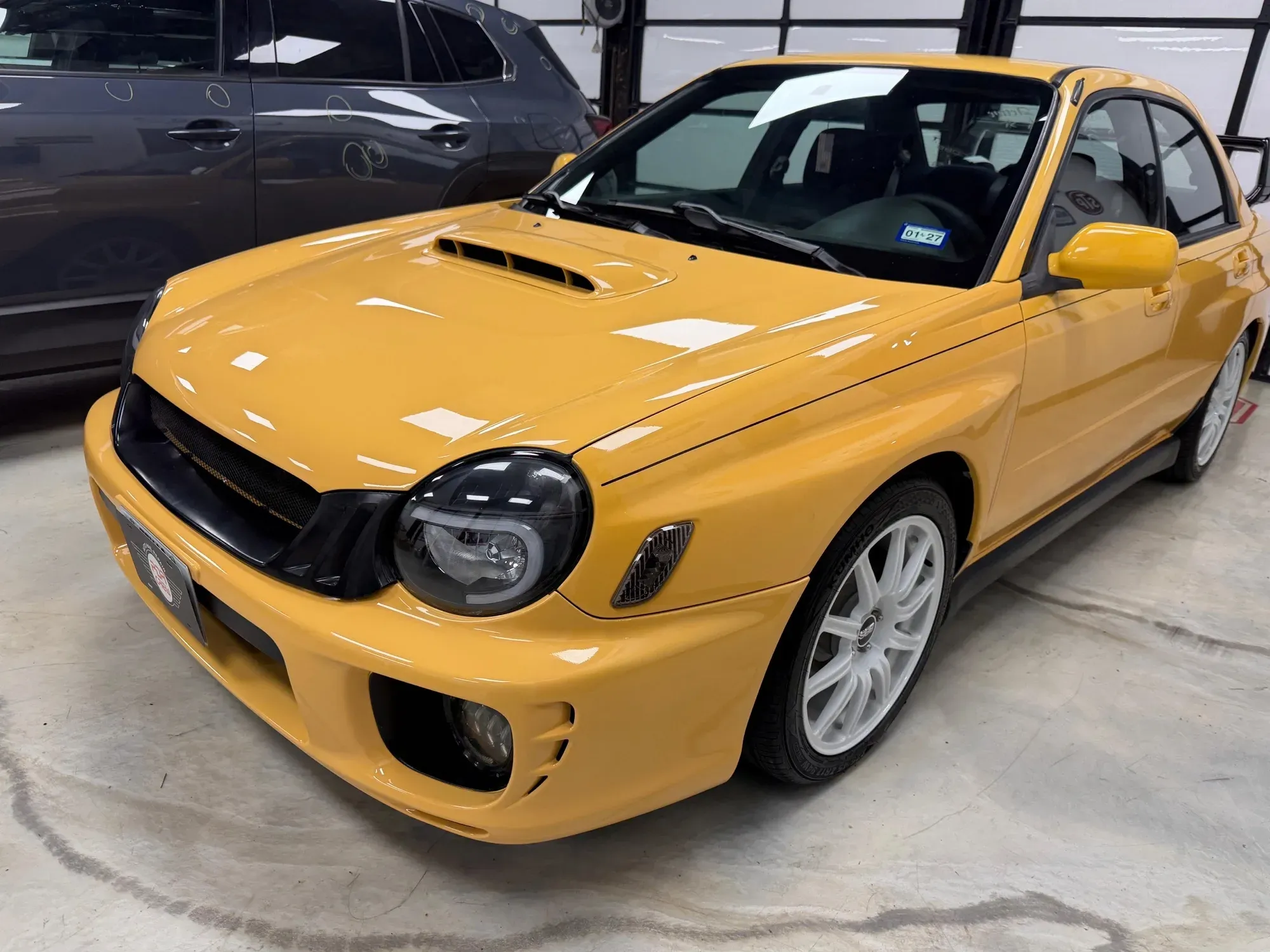 Yellow Subaru WRX with a fresh, glossy finish in the PDR Crew shop