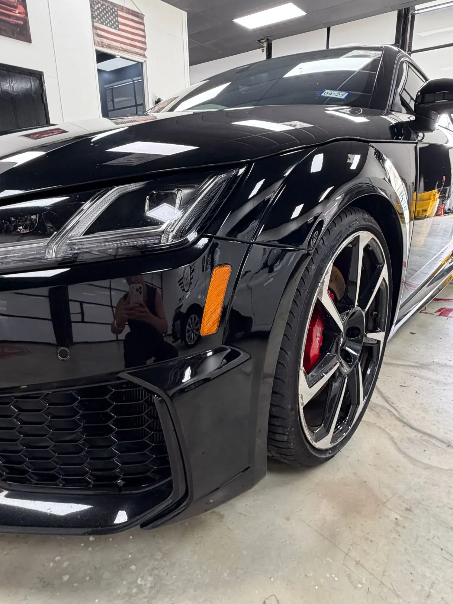 Front fender and bumper of a black Audi TT RS in the shop