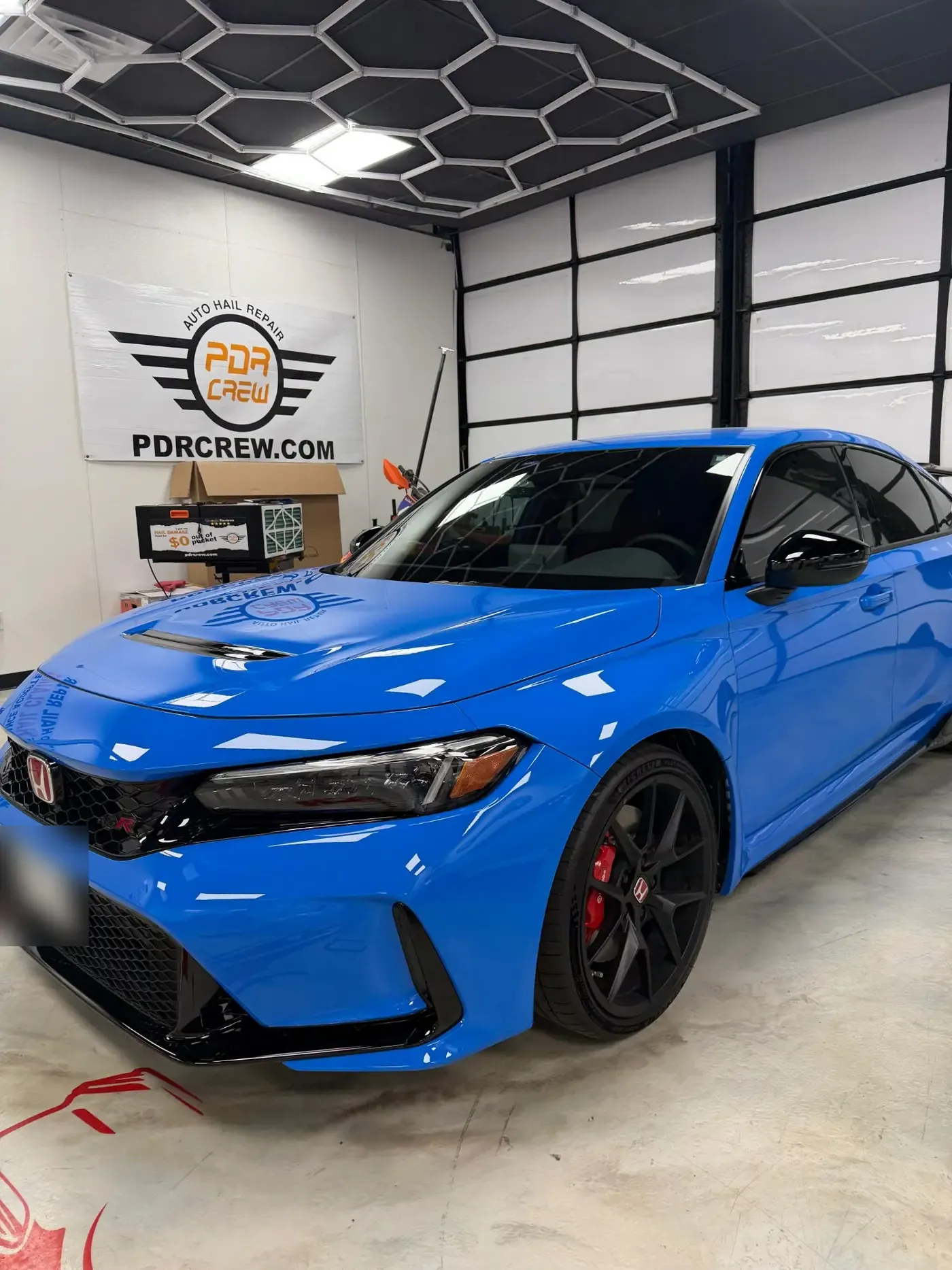 Blue Honda Civic Type R under the shop’s hexagon lights