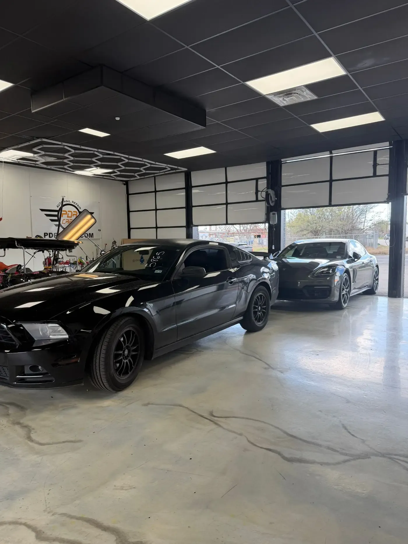 PDR light set up over a black Mustang inside the shop